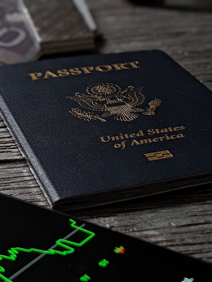 passport-on-a-wooden-table-13080790 Close-up of a United States passport on a rustic wooden table with a smartphone nearby.
